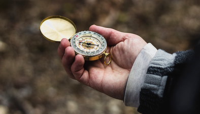Close-Up Of Hand Holding Navigational Compass