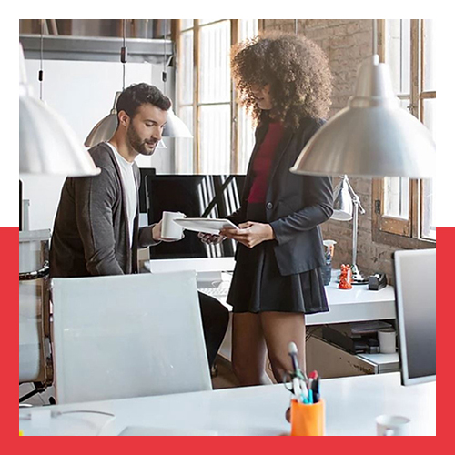 Two coworkers having a discussion in modern office