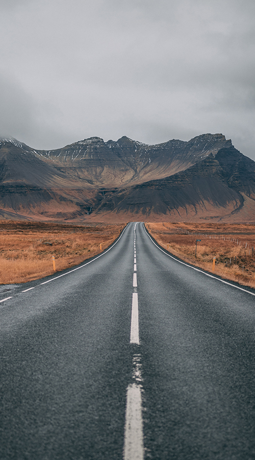 Empty Road Through Grassy Fields